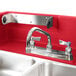 A red Cambro CamKiosk portable self-contained hand sink with two faucets.