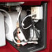 A red Cambro CamKiosk portable hand sink with a water heater and electrical outlets.