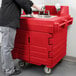 A man washing hands in a red Cambro self-contained portable sink.