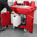 A person pushing a red Cambro hand sink cart.