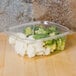 A Genpak clear plastic deli container filled with broccoli and cauliflower.