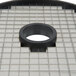 A white metal grid with a black plastic circle on top.