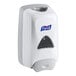 A white Purell FMX-12 dispenser with a clear plastic container and a logo on it.