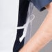 A man wearing a white Intedge cobbler apron with a white belt.