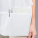 A person wearing a white Intedge cobbler apron with two pockets.