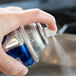 A person spraying Crisco Professional Pan Release Spray on a counter in a home kitchen.