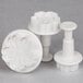 A set of three white plastic flower-shaped cookie cutters.