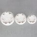 A group of white flower shaped cookie cutters.