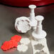 A white Ateco plastic cookie cutter with a flower design.