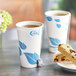 A close-up of a white EcoChoice Leaf Print paper hot cup.