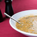 A white Milano melamine bowl filled with soup with a spoon in it.
