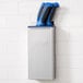 An Edlund stainless steel knife rack with blue inserts holding knives.