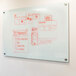 A white Aarco pure glass markerboard with red marker drawings on it.