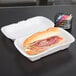 A sandwich in a Genpak white medium shallow foam hinged lid container.