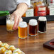 A man pouring a Libbey Glass Can Tasting Glass of beer at a bar