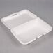 A white styrofoam hinged lid container with two compartments.