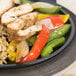 A Lodge round cast iron griddle with a plate of food on a table.