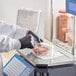 A person weighing meat on a scale and placing it in a Choice Deli plastic bag on a stand.