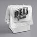 A white Choice Deli Saddle Bag stand with printed Choice Deli bags on it.