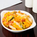 A CAC white stoneware shirred egg dish filled with french fries and cheese.