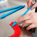 A person using an Ateco blue 6 shape ruffle tool.