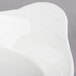A white stoneware shirred egg dish on a white surface.