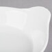 A white stoneware shirred egg dish with a handle on a white surface.