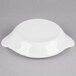 A white stoneware shirred egg dish with handles.