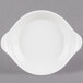 A white stoneware shirred egg dish with handles.