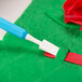 A person using an Ateco sculpturing tool to cut a flower out of fondant.