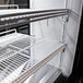 A white Turbo Air refrigerator with shelves and a curved glass door.