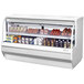 A Turbo Air white refrigerated deli case with food on shelves.