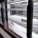 A close-up of the glass door on a Turbo Air White Refrigerated Bakery Display Case.