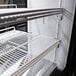 A white Turbo Air deli case with shelves and a curved glass door.