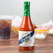 A Crystal hot sauce bottle on a table in a restaurant.