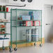 A Regency green wire security cage kit in a room with metal shelves holding food items.