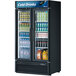 A Turbo Air black glass door refrigerator full of soda and cans.