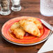 A Carlisle Mingle melamine bread and butter plate with croissants on it.