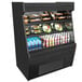 A black Structural Concepts Oasis air curtain merchandiser with food on shelves.