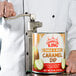 A man using a Garde Standard-Duty manual can opener to open a can of caramel dip.