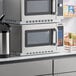 Two Solwave stackable commercial microwaves on a counter in a professional kitchen.