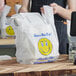 A man holding a white plastic bag with a smiley face on it.