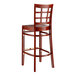 A Lancaster Table & Seating mahogany wood bar stool with a window back and mahogany wood seat.