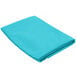 A teal square cloth table cover folded up on a white background.