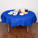 A table with a Creative Converting cobalt blue table cover, plates, and cups.