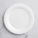A close up of a white Visions Wave plastic plate with a spiral design.