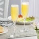 Two Libbey tall flute glasses of champagne on a table.