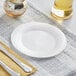 A Visions white plastic plate with a knife on it.