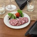 A Visions plastic plate with meat and vegetables on a table.