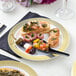 A Visions white plastic plate with food on a table.